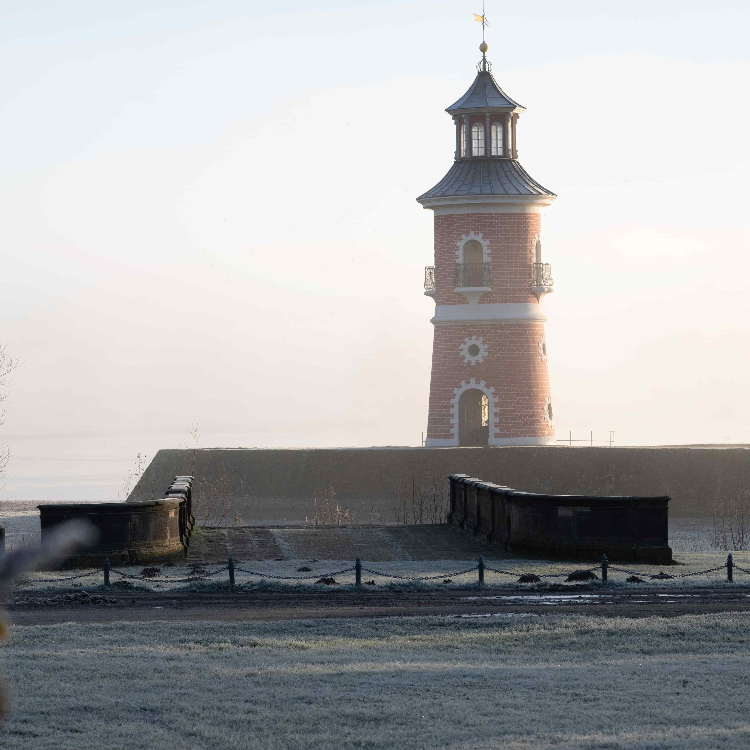 Leuchtturm Moritzburg – Morgenstimmung am Hafen Leuchtturm Moritzburg am Hafen des Fasanenschlösschens im Morgennebel, mit Brücke im Vordergrund