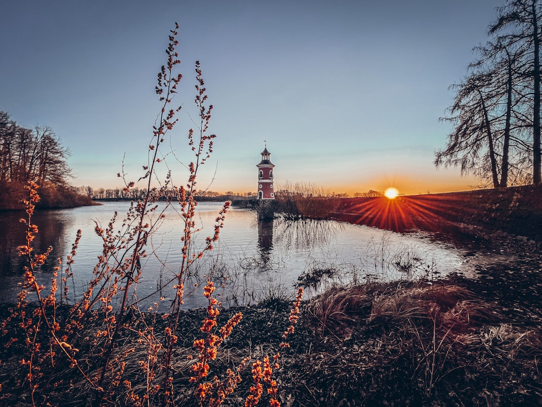 Photo by Sarah Kromeyer a light house sitting on top of a body of water