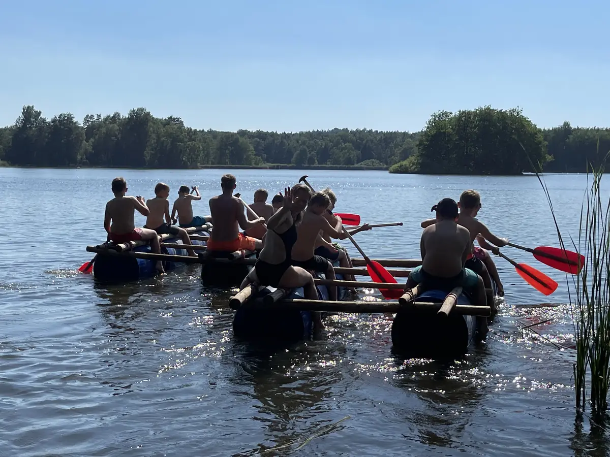 Floßbau-Teamtraining mit Ausfahrt auf dem Mittelteich Jugendgruppe paddelt auf einem selbst gebauten Floß aus Fässern und Holzstangen über den Mittelteich